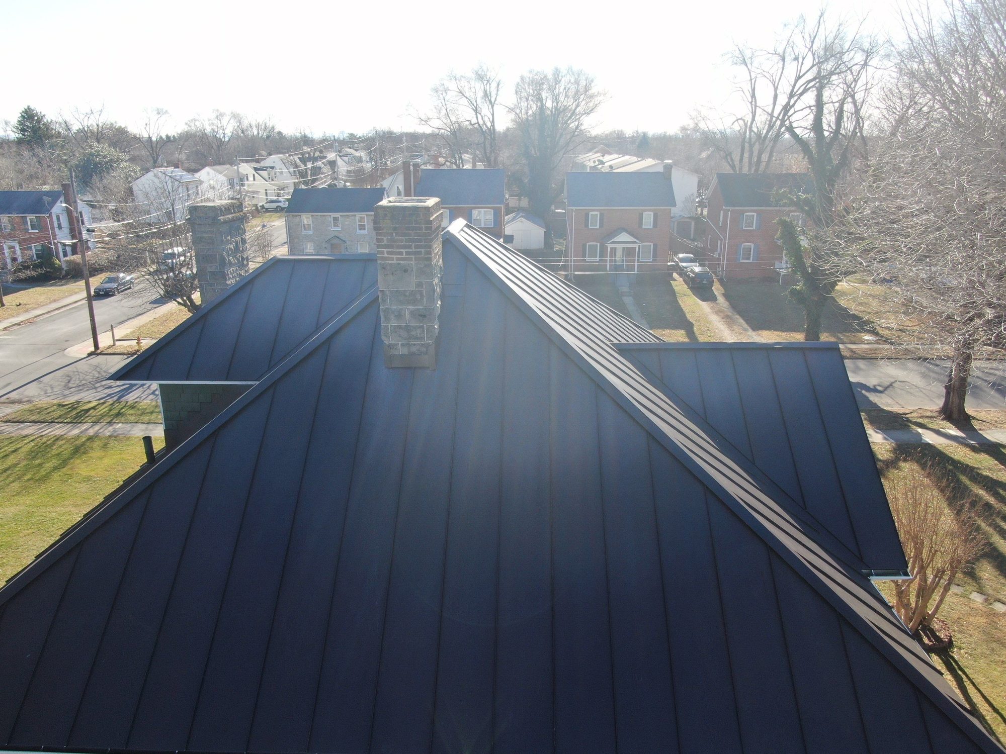 Dark standing-seam roof with a stone chimney