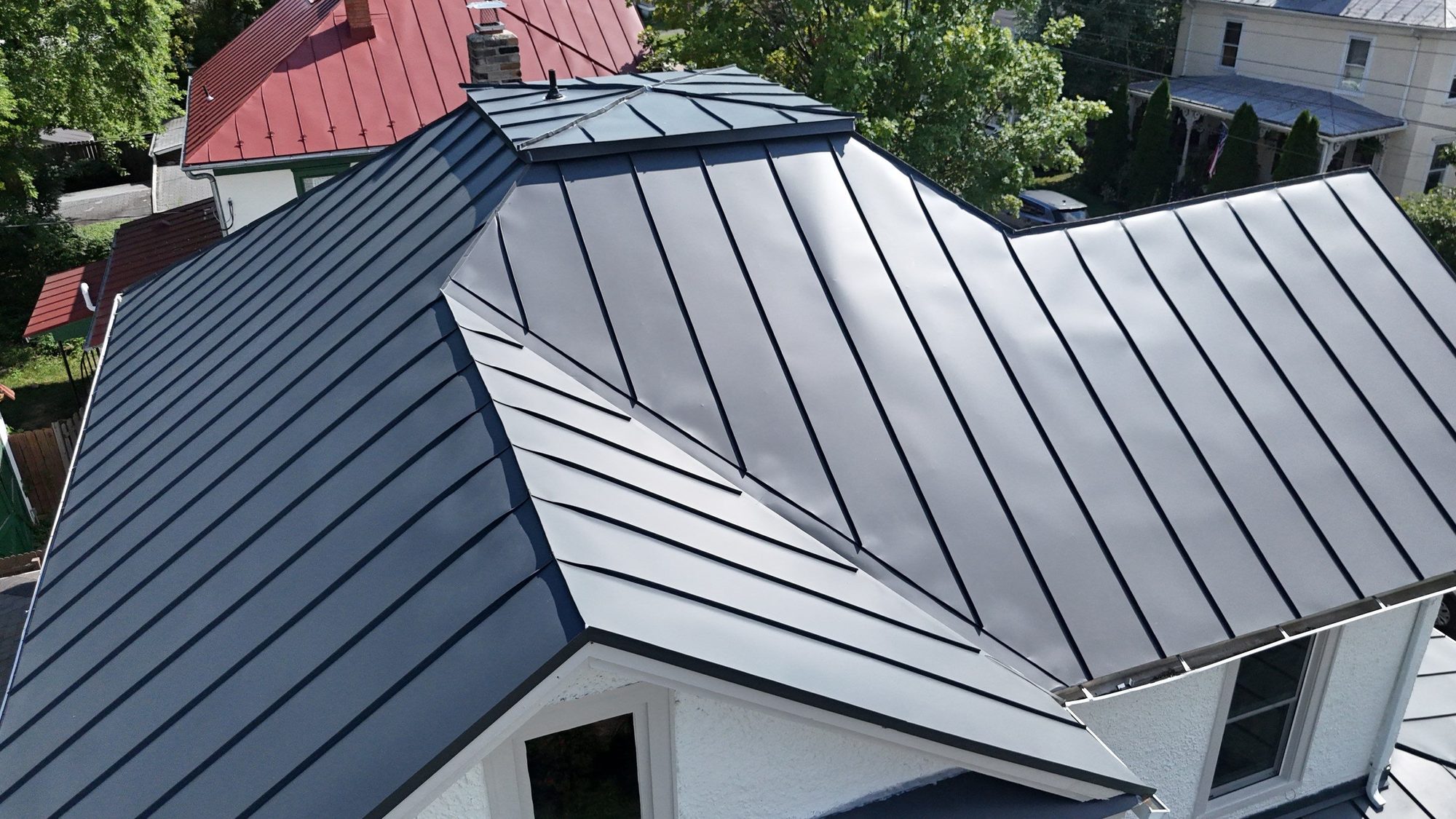 Charcoal standing-seam roof with hips and valleys